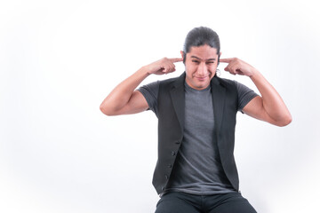 Fototapeta premium Person with white background, man making gestures, he covers his ears with his fingers, there is a lot of noise and it bothers him, he does not want to hear what they are saying