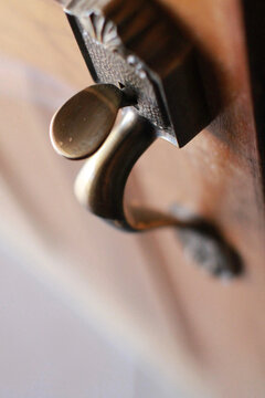 Vertical closeup shot of a metal handle on a wooden door