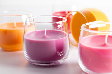 Beautiful colored candles in glass on white background. Aroma candles with colorful wax. 