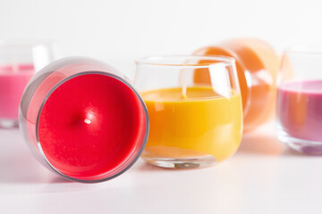 Beautiful colored candles in glass on white background. Aroma candles with colorful wax. 