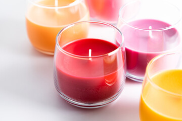 Beautiful colored candles in glass on white background. Aroma candles with colorful wax. 