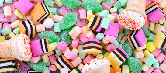 Halloween Trick or Treat Social Media Web Banner. Bright colorful candy on pale blue wood table background overhead.