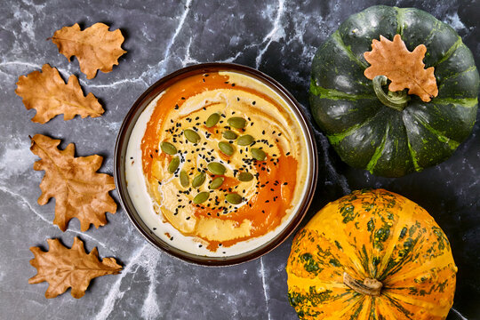 Creamy pumpkin soup with cream and black cumin and pumpkin seeds