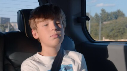 Boy with fastened seat belt traveling by car