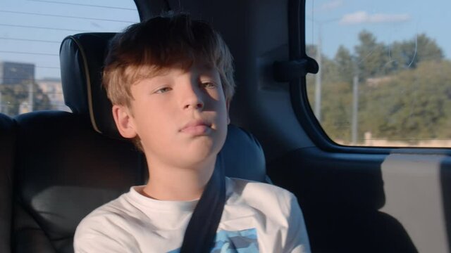 Boy with fastened seat belt traveling by car