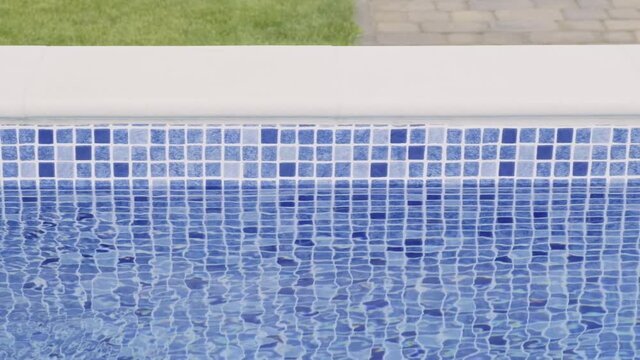 Blue tiles in the outdoor pool. The movement of water on the surface. Slow motion
