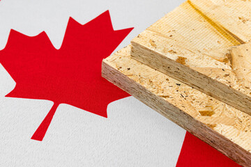 OSB, oriented strand board, plywood on flag of Canada. Trade war, tariffs, fair trade and lumber, logging industry concept.

