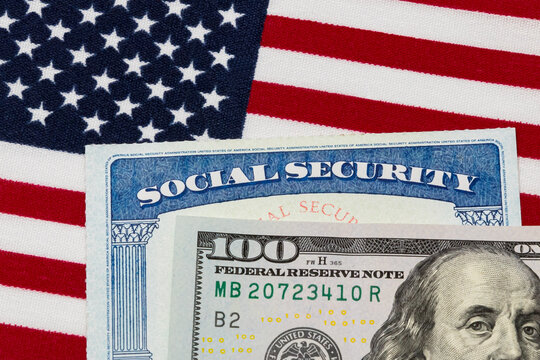 Social security card, 100 dollar bill and American flag. Concept of social security benefits payment, retirement and federal government benefits