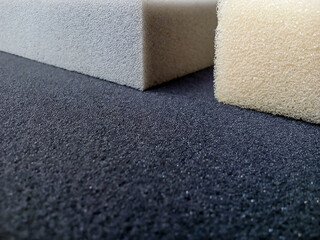 square piece of thick gray, yellow and black sponge foam. block material with coarse texture and pore