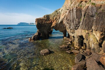 Drone view of an elephant-like natural stone arch on the seashore