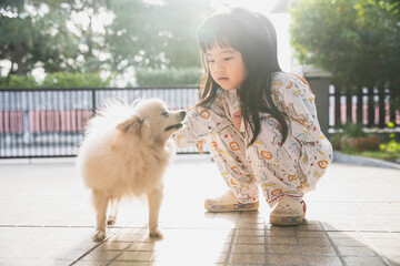 Little girl playing with her dog. Outdoor portrait. happy child girl with her dog at home.