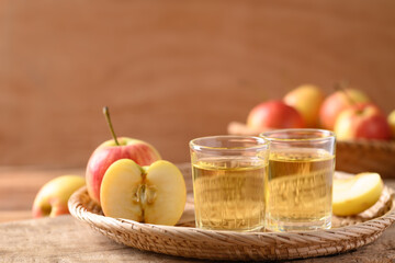 Fresh red apple fruit and juice in a basket on wooden background