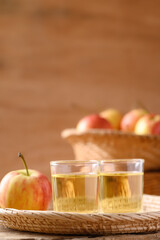 Fresh red apple fruit and juice in a basket on wooden background