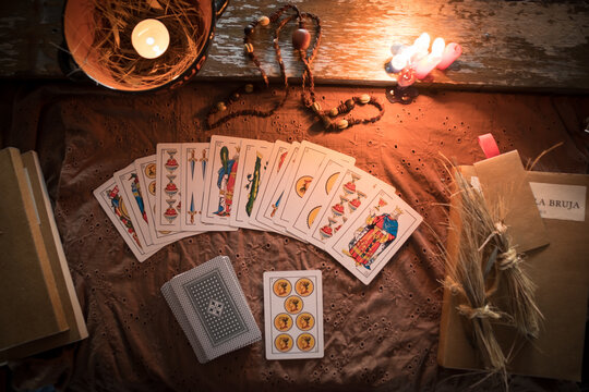 Adivinaci&oacute;n con naipes en una sesi&oacute;n de cartomancia con velas y amuletos