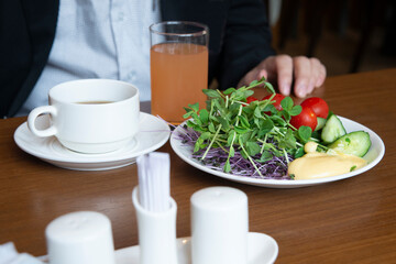 Man sits at dining table with healthy breakfast.