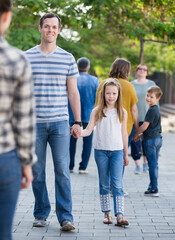 Smiling people of different ages walk in a park on holiday