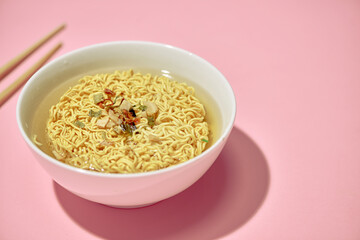 Chopsticks holding instant Asian noodles with natural light