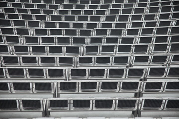 Empty rows of wire seats and theater or stadium cushion.
