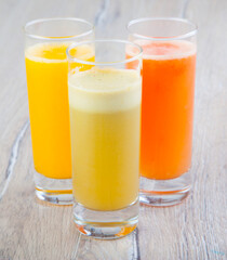 natural vegetable and fruit juices in a transparent glass on a wooden background