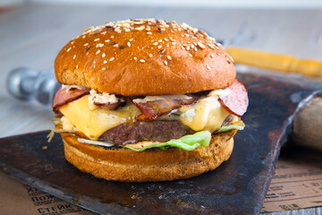 burger with meat on wooden round board with ax