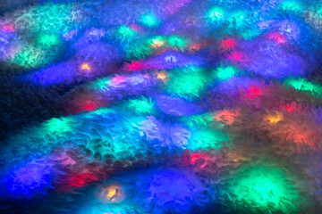 Multicolored lights on the surface of the faux fur