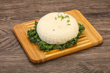 Caucasian suluguni round cheese piece