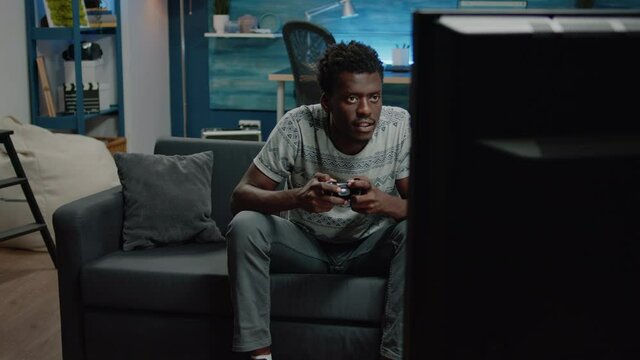 African american man losing at video games on console for fun. Black person playing online game using controller on television. Afro adult with joystick feeling irritated about lost play on tv