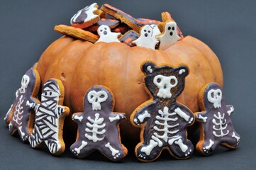 Halloween treat. Gingerbread in pumpkin on dark background.
