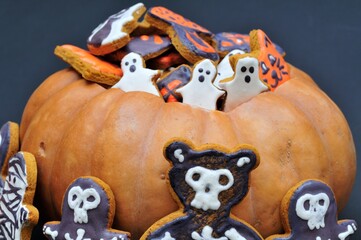 Halloween treat. Gingerbread in pumpkin on dark background.
