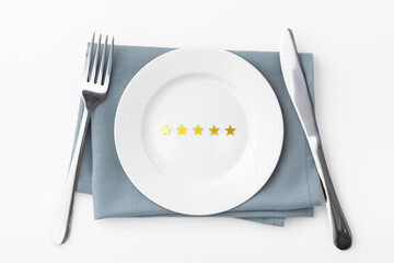 Five gold stars on white plate with fork and knife isolated on white background