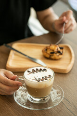person holding coffee and cake
