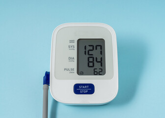 Blood pressure monitor on light blue background.