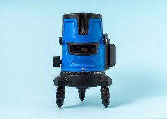 Electronic laser level on light blue background.