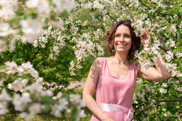 A woman near a blooming spring tree. Romantic happy mood.