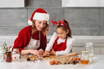 Mother and daughter making Christmas cookies in the kitchen 