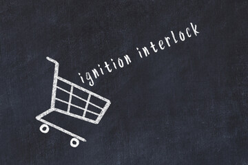 Chalk drawing of shopping cart and word ignition interlock on black chalboard. Concept of...