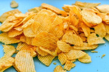 Delicious home made potato chips with sea salt and black pepper against a rustic background. Delicious snack served with sauce. Fast food.Beer snacks