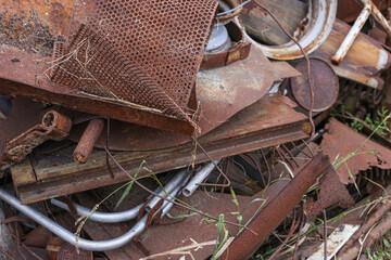 A pile of old metal farm parts now rusting away and ready to be used as scrap metal.