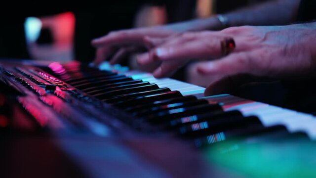 Musicians playing at a wedding. Man is playing synthesizer. Stage lights