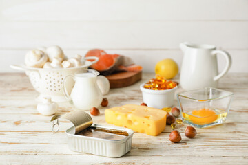 Different healthy products with vitamin D on light wooden background