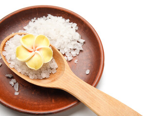 Plate with sea salt and flower on white background