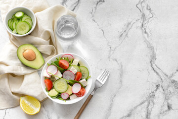 Plate with fresh salad on light background