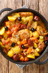 Macanese Style Portuguese Chicken Galinha a Portuguesa Po Kok Gai close up in the pan on the table. Vertical top view from above