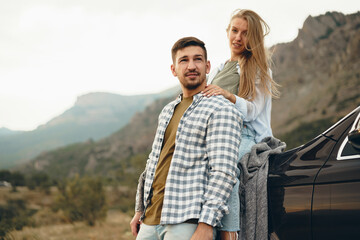 Young couple is on romantic trip to the mountains by car