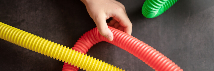 anti stress sensory pop tube toys in a children's hands. a little happy kids plays with a poptube...