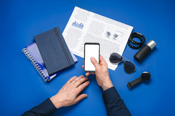 Businessman using mobile phone on color background