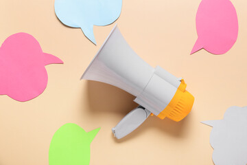 Fototapeta premium Modern megaphone and speech bubbles on color background