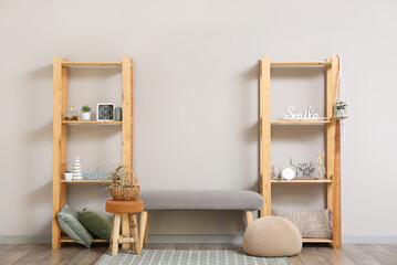 Modern TV stand with shelves and decor near light wall