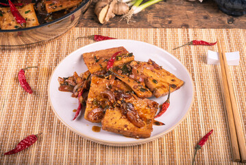 Fried tofu with spicy sauce on a plate - Asian appetizer.