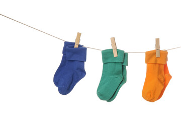 Different baby socks hanging on rope against white background